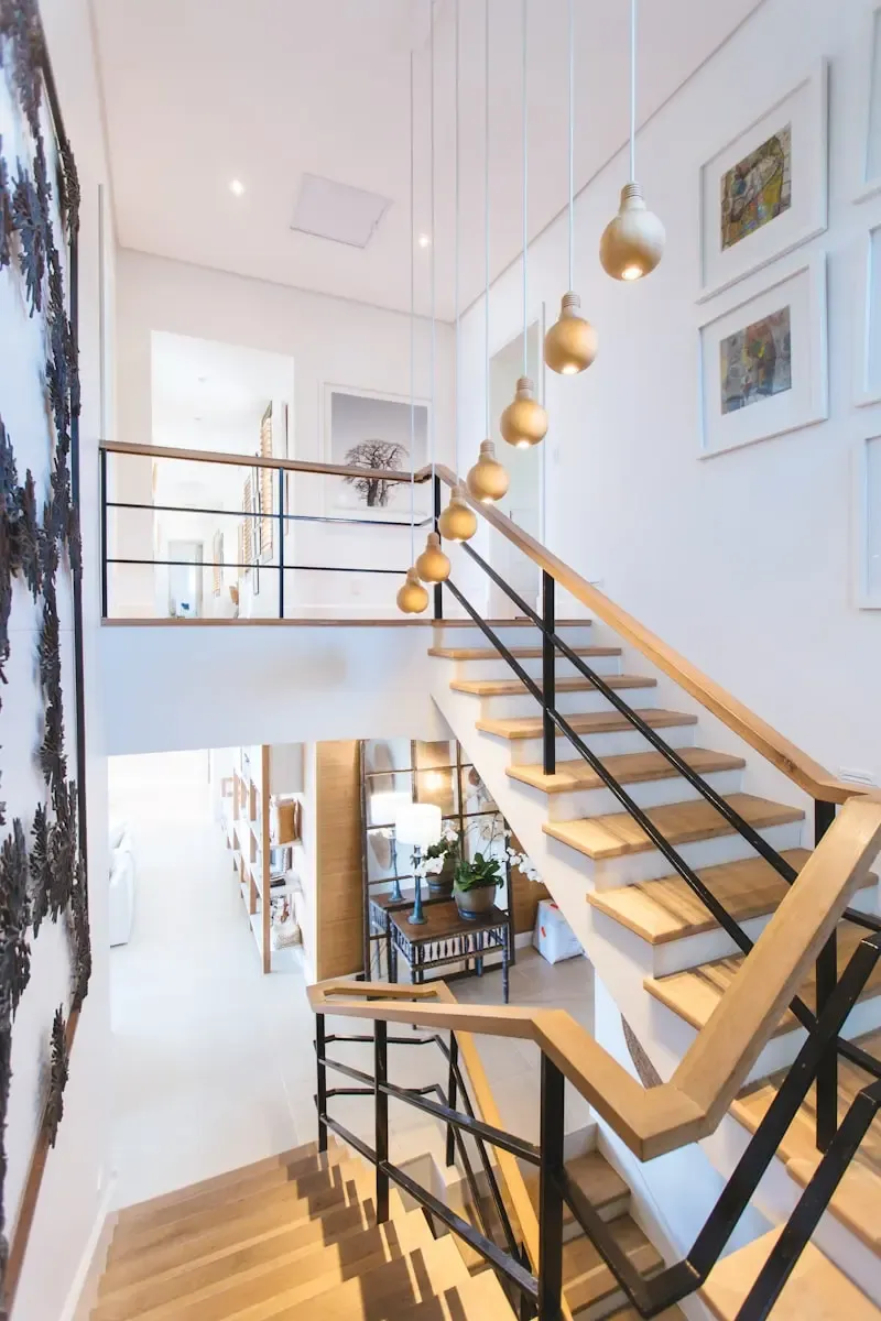 Finished double-height entrance hall with an oak and steel staircase and pendant lighting
