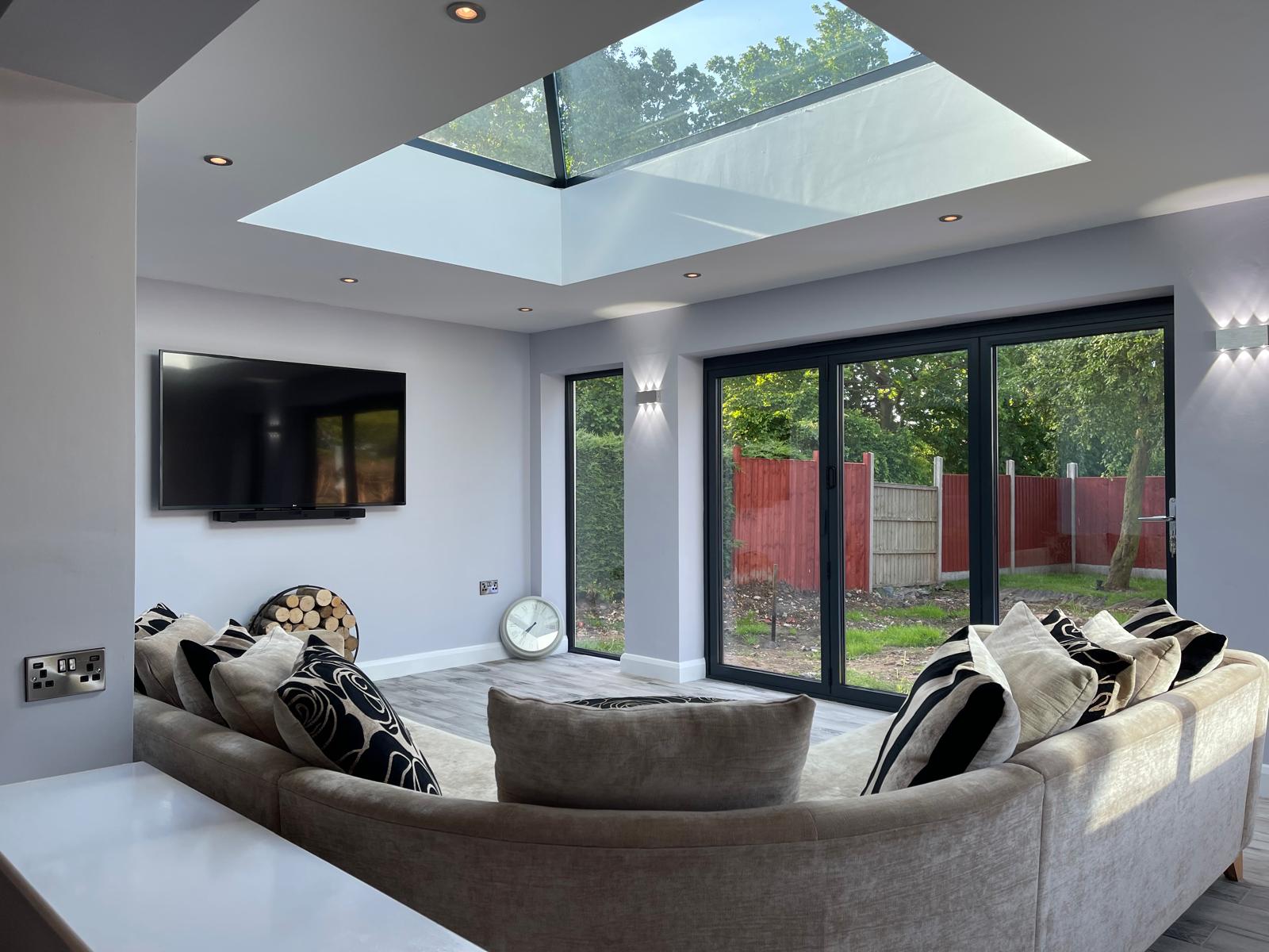 Completed open-plan extension interior with a large roof lantern and full-height glazing to the garden